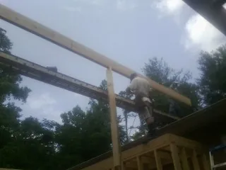 Carpenter setting a ridge beam over a new addition frame — Ice Dam Removal by Roofing Brothers in Guilford