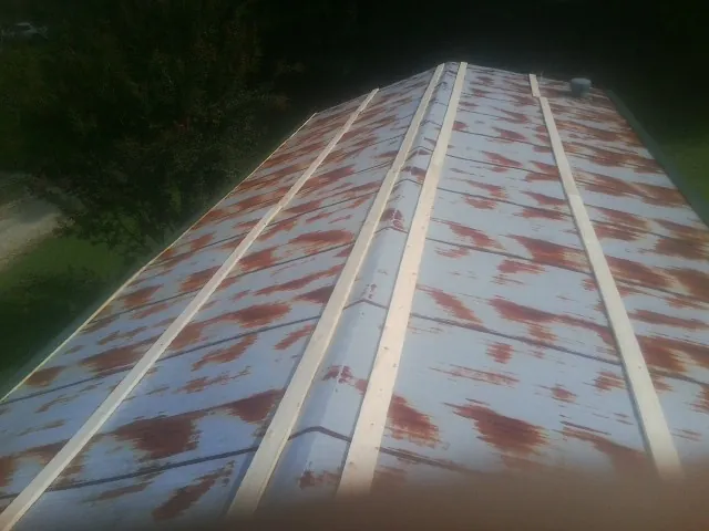 Rusted metal roof panels with new wood purlins before replacement — Storm Damage Roof Repair in Guilford by Roofing Brothers