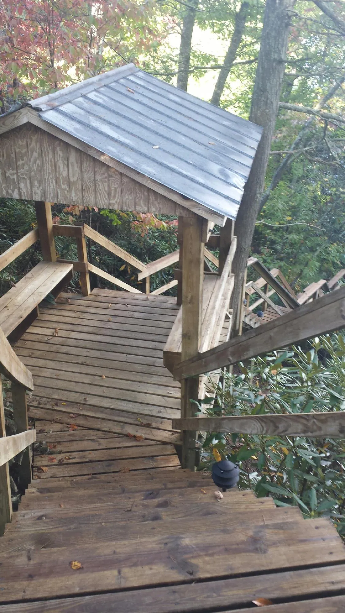 Metal roofed shelter over wooden steps on a wooded walkway — Skylight Repair & Installation work by our crew in Guilford